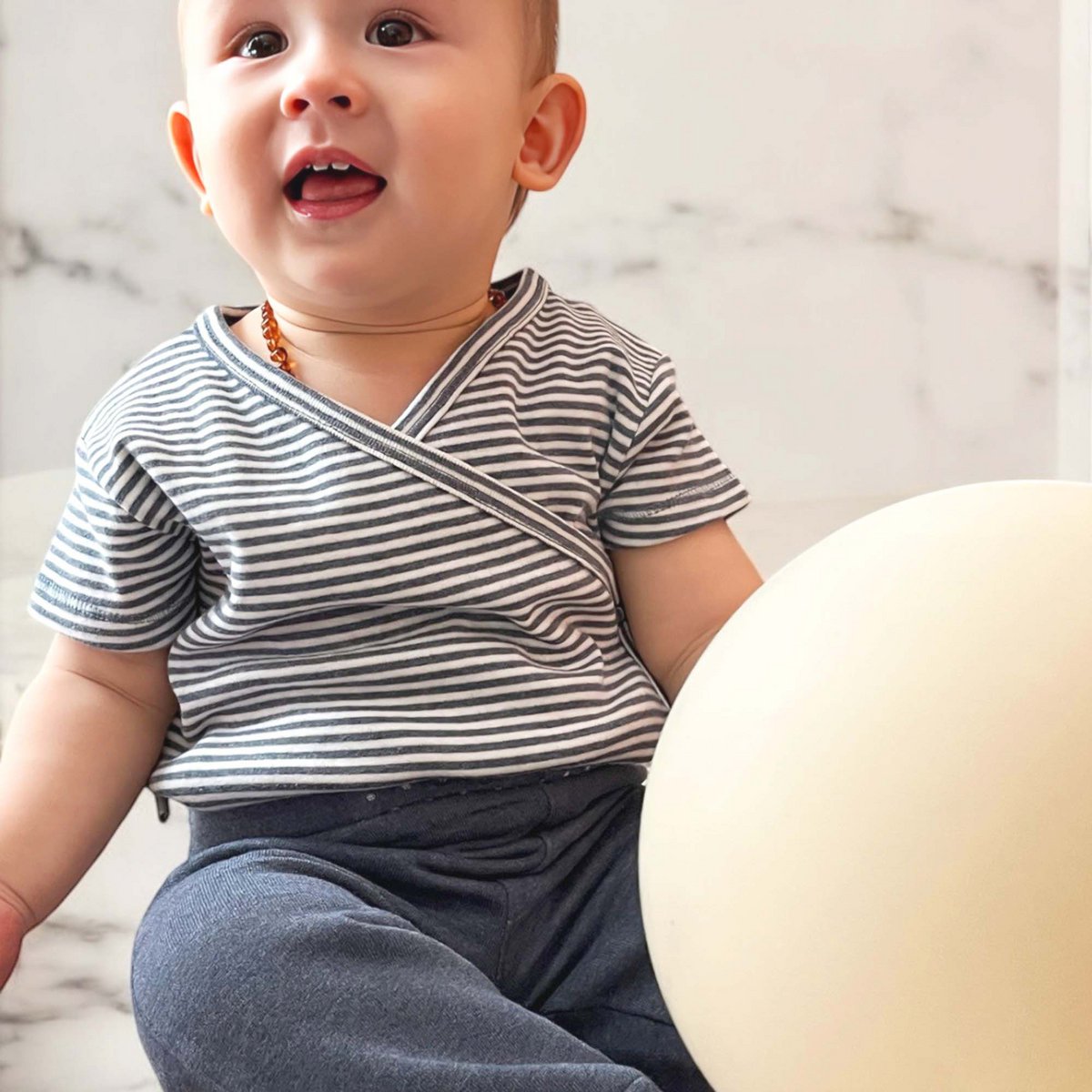 Baby Kimono Wickelbody aus Bio-Baumwolle, kurzarm und indigogestreift.