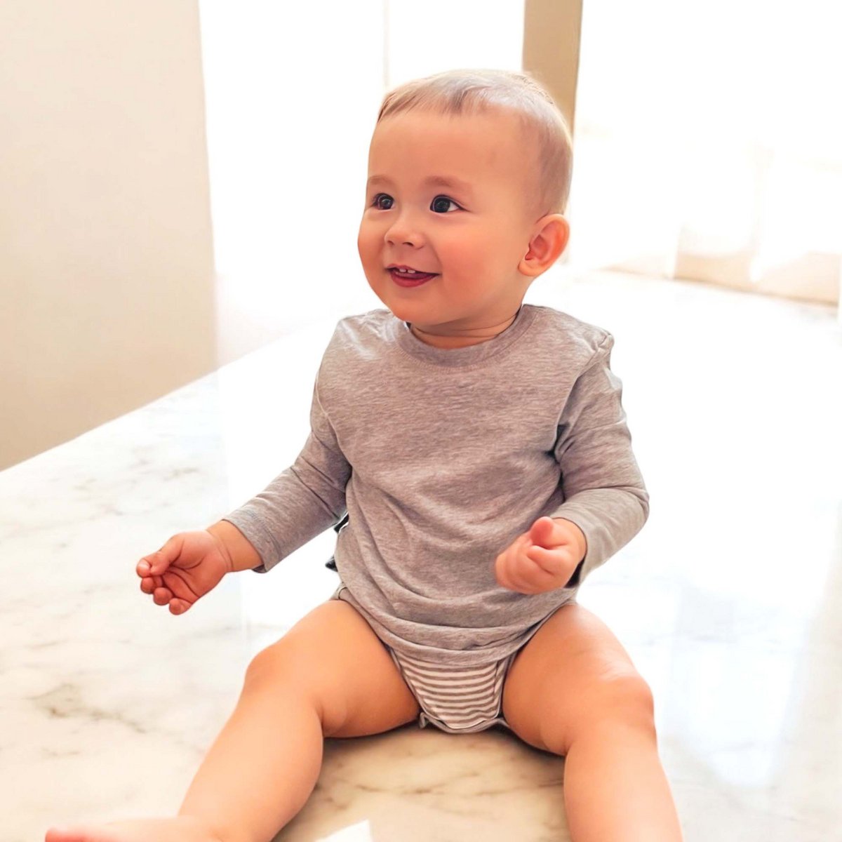 Grauer Baby Langarm Body aus Bio-Baumwolle mit T-Shirt Einteiler und 2-Schicht-Look.