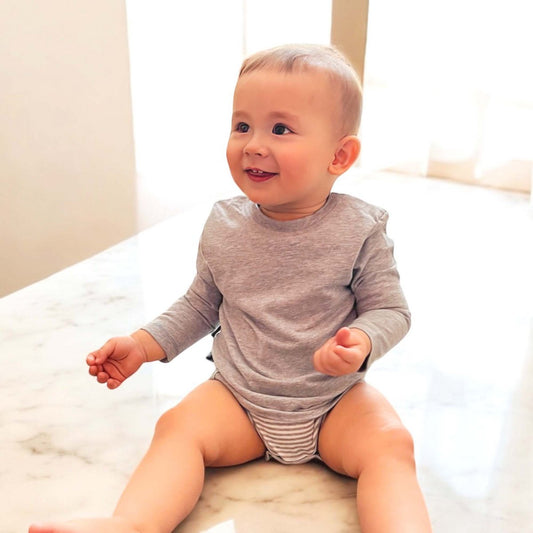 Grauer Baby Langarm Body aus Bio-Baumwolle mit T-Shirt Einteiler und 2-Schicht-Look.