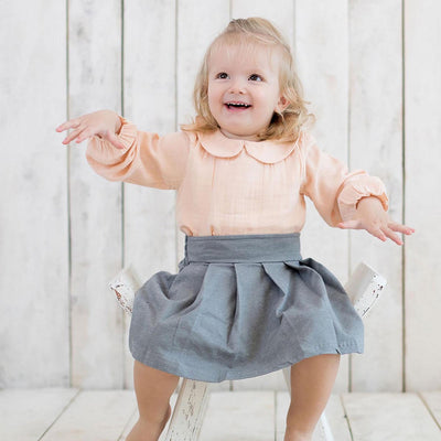 Lachsfarbene Mädchen Bio-Musselin Body Bluse mit Peter Pan Kragen.